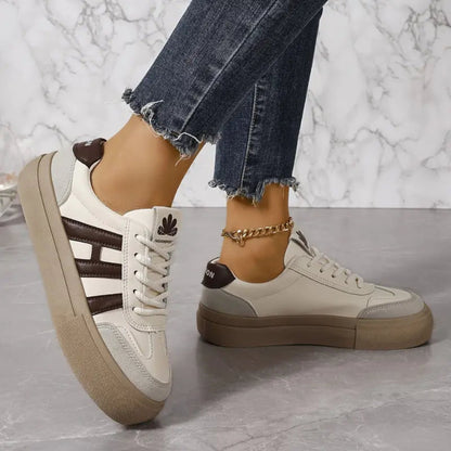 White sneakers with brown-and-beige side stripes, lace-up, tan platform sole.