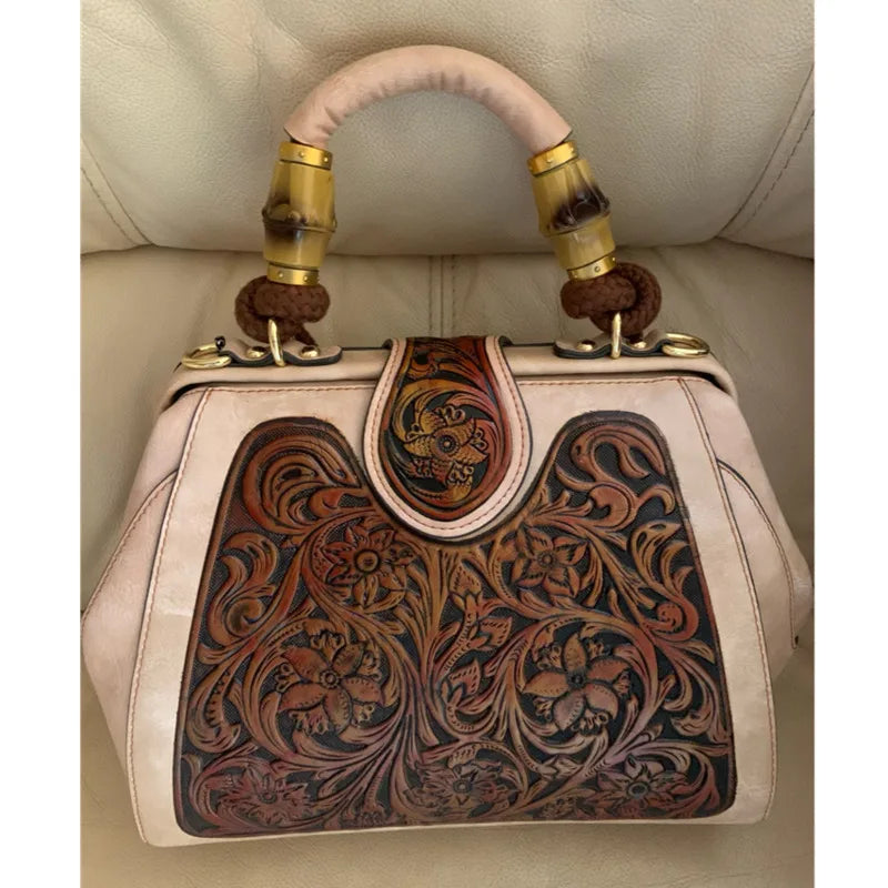 Beige leather handbag with front carved floral panel and gold-tone ring handles