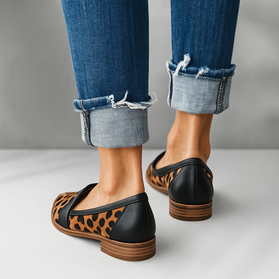 Black slip-on loafers with leopard print vamp panels and brown sole