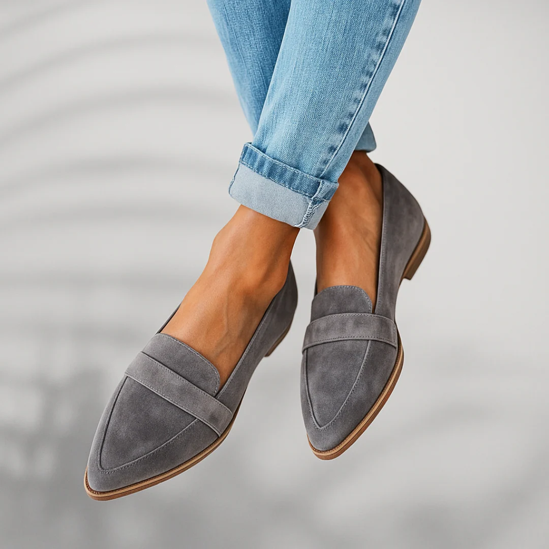 Grey suede slip-on loafers with stitched seam detailing and brown sole