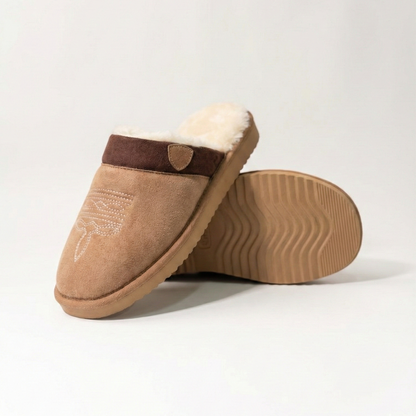 Cowboy slippers in chestnut suede with dark strap, plush lining, and ribbed outsole.