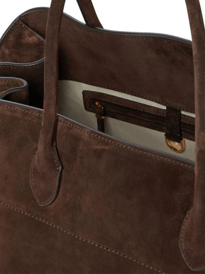 Close-up of brown suede tote with top handles and front zip pocket