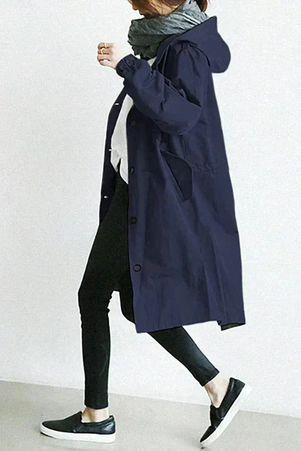 Women’s raincoat in navy blue with oversized hood and button-front, knee-length.