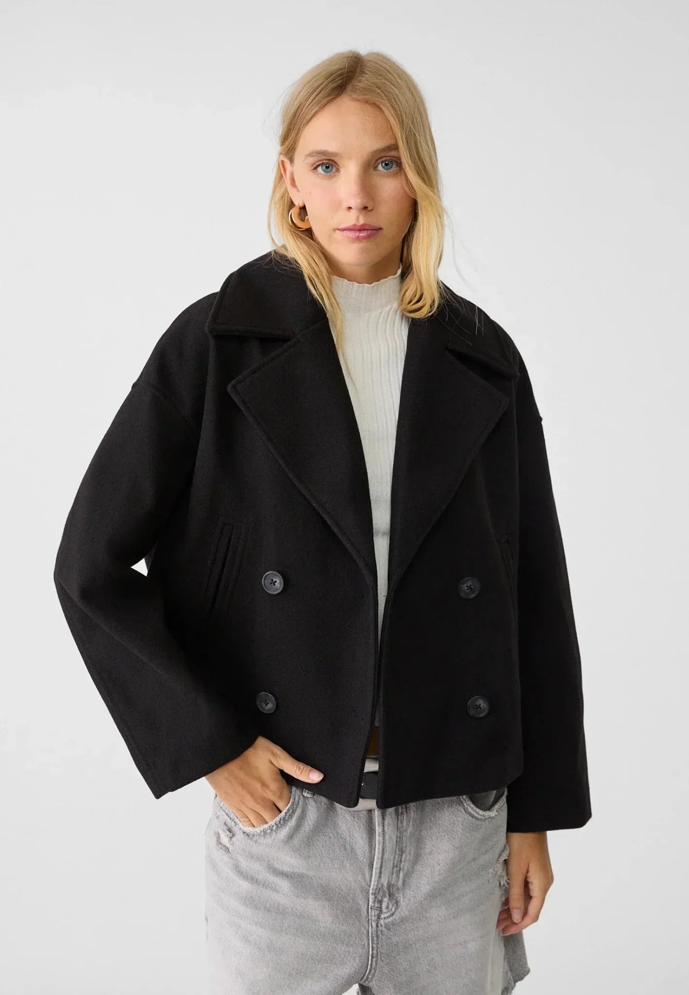 Cropped double-breasted jacket, black, worn over a light top with denim jeans