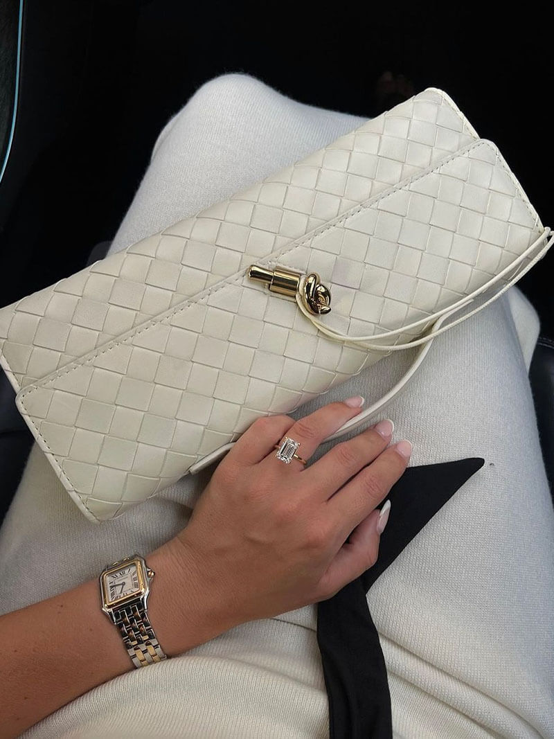 Off-white woven vegan leather clutch with gold clasp and chain-style shoulder strap
